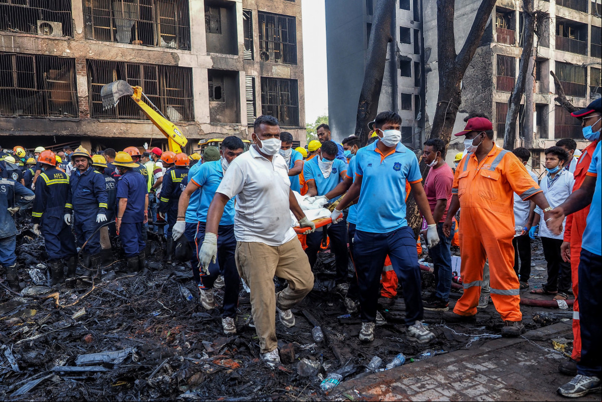 Rescue officials carry a victim's body at the site where Air India flight 171 crashed in a residential area near the airport in Ahmedabad on June 12, 2025. A London-bound enger plane crashed in the Indian city of Ahmedabad on June 12 and all 242 people on board were believed killed, with the jet smashing into buildings housing doctors and their families. (Photo by Sam PANTHAKY / AFP) (Sam PANTHAKY / AFP) Rescue officials carry a victim's body at the site where Air India flight 171 crashed in a residential area near the airport in Ahmedabad on June 12, 2025. A London-bound enger plane crashed in the Indian city of Ahmedabad on June 12 and all 242 people on board were believed killed, with the jet smashing into buildings housing doctors and their families. (Photo by Sam PANTHAKY / AFP)/Sam PANTHAKY / AFP